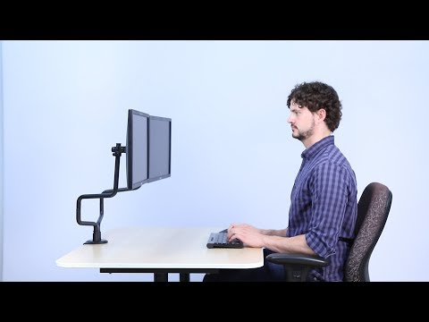 Video Studio image Metal Art Dual Monitor Arms - preview shows man at desk looking at monitors